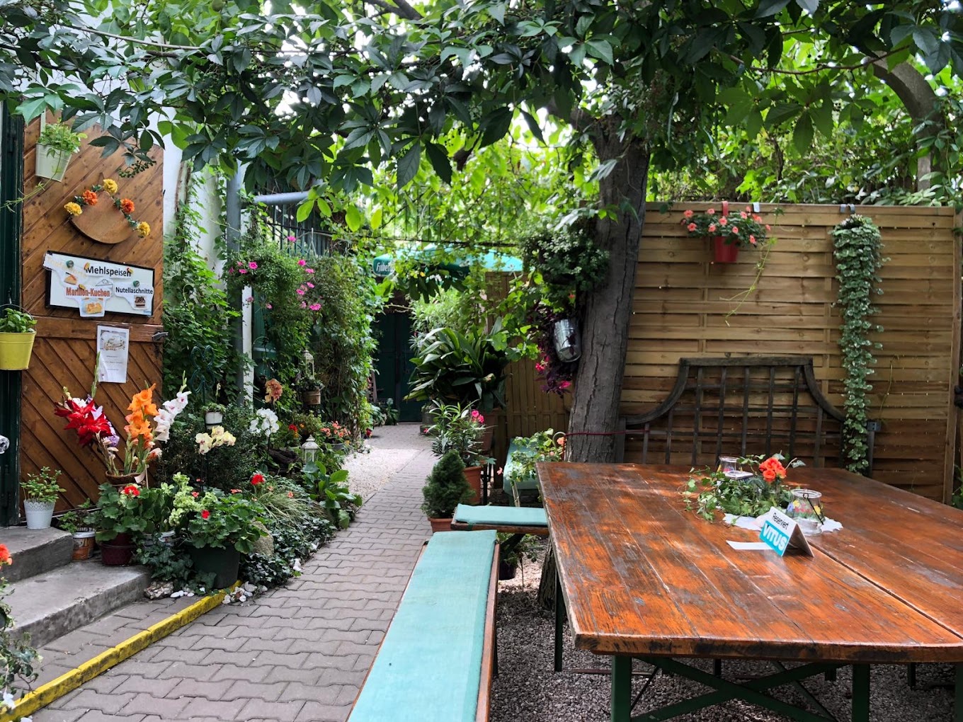 Begrünter Gastgarten mit Tischen